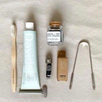 a toothbrush, toothpaste, and other items are laid out on a table