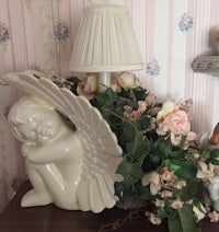 an angel figurine sits on a table next to flowers