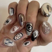 a person holding a nail with designs on it